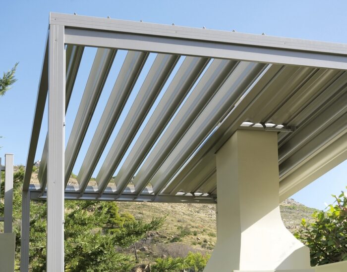 Πέργκολα αλουμινίου με ρυθμιζόμενες περσίδες για έλεγχο φωτός και αερισμού σε κήπο